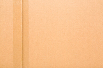 Fototapeta premium Transparent scotch tape on closed brown carton pack. Closeup. Empty place for text. Top down view.