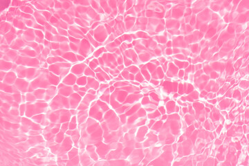 Fototapeta premium Pink water bubbles on the surface ripples. Defocus blurred transparent pink colored clear calm water surface texture with splash and bubbles. Water waves with shining pattern texture background