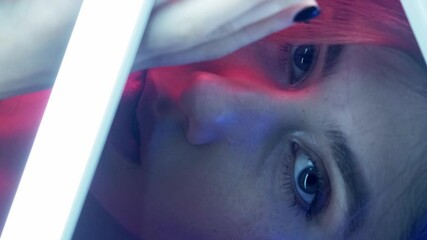 Vertical video. Neon light face. Cyberpunk beauty. Aesthetic cosmetology. Pink blue color glow sensual woman with full lips in smoke posing with white LED lamp illumination on dark night background. - Powered by Adobe