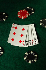 A thrilling poker game unfolds on a vibrant green felt table, showcasing five playing cards and scattered chips, capturing the essence of competition and strategy at play