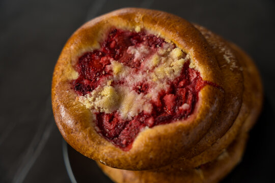 Close-Up of Traditional Czech and Slovak Kolach Pastry with Strawberry Filling on Black Background