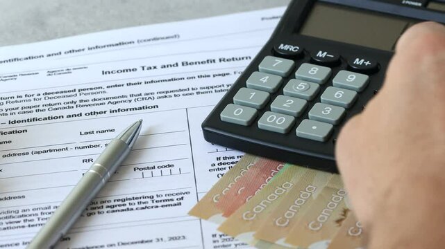 Income tax return in Canada. Financial concept. Tax form, Canadian dollars and tax calculation on calculator. close up