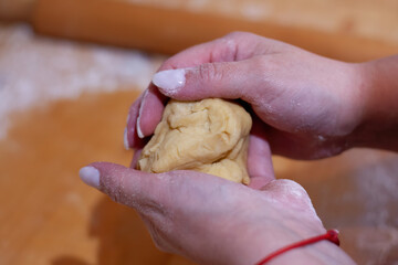 Hands Kneading Dough on Floured Surface
