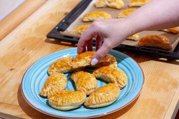 Hand Serving Freshly Baked Pastries on Blue Plate
