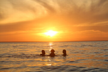 silhueta de crianças não identificadas brincando no por do sol no rio tapajós, em belterra,...