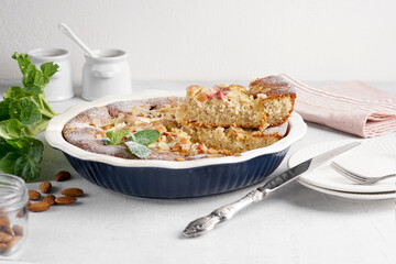 Rhubarb custard tart or pie in ceramic form on the table. Summer healthy dessert. Selective focus