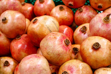 Ripe, juicy pomegranates on the counter at the food market. Background with pomegranates