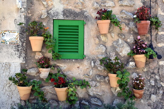Pared con peque&ntilde;a ventana verde y masetas