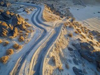 Fototapeta premium Aerial view of a forked desert path surrounded by rocks and sparse vegetation, capturing the essence of choice and direction in a barren landscape.