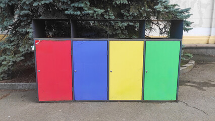 Obraz premium Colored trash bins red, blue, yellow, green for organic waste, paper, plastic, metal, glass in the city park of the city