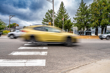  Motion blurred vehicle passing over a intersection crosswalk markings