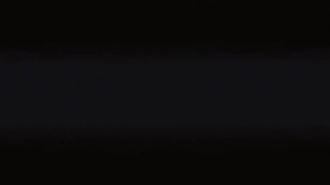 Camera flies through a dark, futuristic corridor illuminated by parallel pulsing beams of bright, white light. The walls of the corridor are composed of a complex, grid-like structure