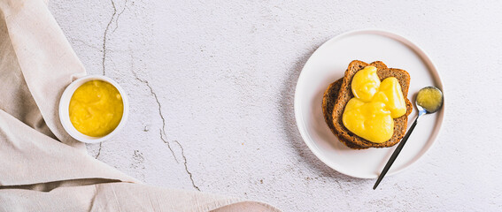 Delicious toasts with honey butter on a plate on the table top view web banner