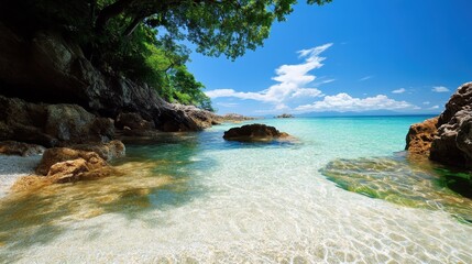 Fototapeta premium A picturesque view of a clear turquoise sea beneath a bright blue sky, framed by rocky formations and lush foliage. A scene epitomizing serenity and natural beauty.