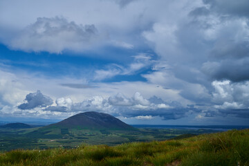 Cumulus or cluster clouds moving over a field with blue sky background in sunny weather in a wide angle shot