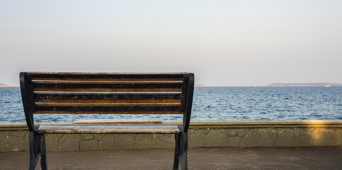 Empty bench facing the sea, symbolizing solitude and peaceful moments by the ocean.