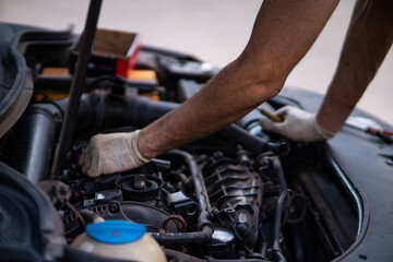 A skilled mechanic performs diagnostics under the hood of a car, meticulously inspecting components to identify issues.