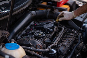 A skilled mechanic performs diagnostics under the hood of a car, meticulously inspecting components to identify issues.