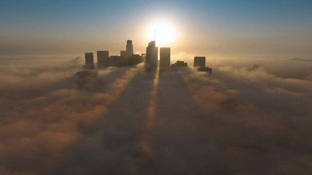 This aerial hyper lapse features vibrant Downtown Los Angeles at sunrise, with the iconic skyline surrounded by soft clouds, creating a mesmerizing view that captures the citys essence