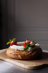 choux pastry creamy cheese cake with mint and strawberries on a craft background
