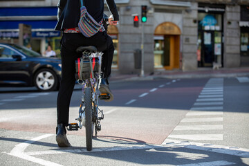 Chica en bicicleta esperando para cruzar un semáforo