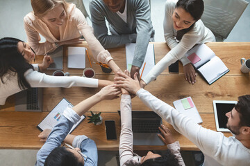 Group of people putting their hands together for united, cooperation and teamwork concept, top view