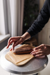 Woman pastry chef serving chocolate eclair on baking sheet