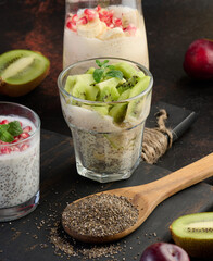 Glass with chia seeds and yogurt with kiwi pieces on table