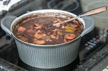Traditional Brazilian feijoada in a rustic pan