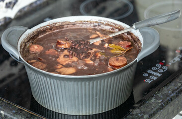 Traditional Brazilian feijoada in a rustic pan