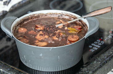 Traditional Brazilian feijoada in a rustic pan