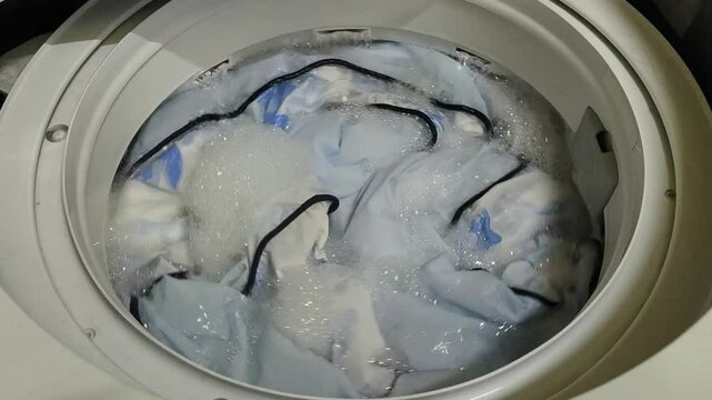 Washing blankets in a top-loading washing machine. Laundry and house keeping concept