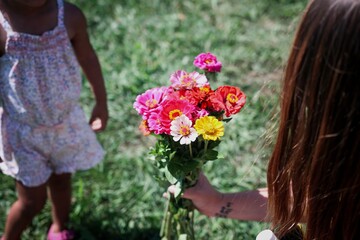 Mother handing flowers to daughter