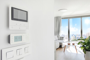 Modern air conditioning control, intercom display, switches on white wall in cozy light apartment, free space
