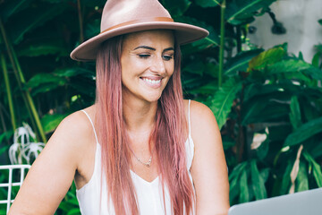 Beautiful blogger in hat working in garden