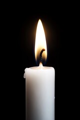 A white candle with a flame on a black background