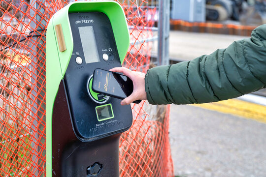 Passenger in Ontario uses Presto card phone app to pay transit fare on a go train trip to union station. Technology innovation on modern transportation concept. 
