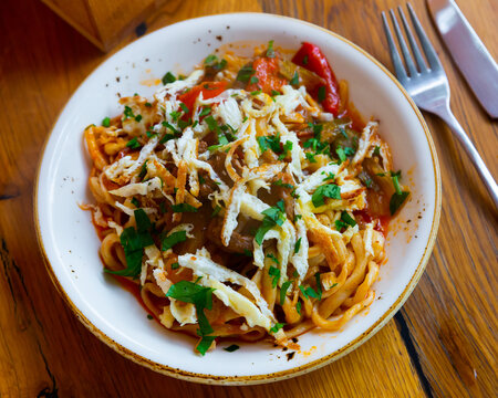 Traditional kaurma laghman noodles fried with vegetables, lamb and omelette. Popular asian dish