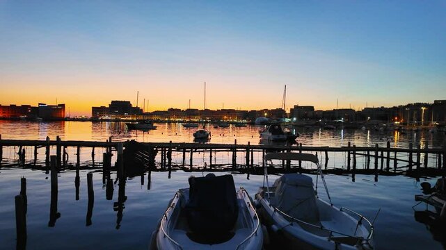 Magical sunset in the port of Anzio in Italy. Reflections in the water and vivid colors illuminate the scene with the boats moving. Located on the Tyrrhenian Sea dedicated to Sea dedicated to tourism