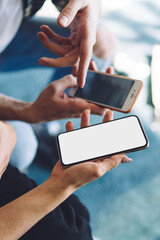 Crop man and woman using mobile gadgets