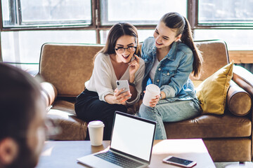 Happy young women using smartphone at home