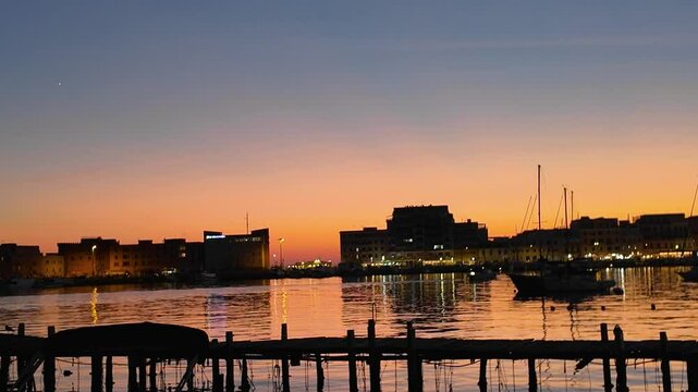 Magical sunset in the port of Anzio in Italy. Reflections in the water and vivid colors illuminate the scene with the boats moving. Located on the Tyrrhenian Sea dedicated to Sea dedicated to tourism
