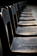 A row of wooden chairs sitting next to each other