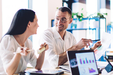 Glad colleagues communicating in office