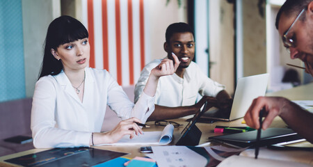 Convincing multiracial colleagues discussing project and using laptop in conference room