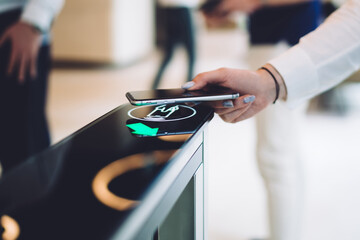 Stylish woman walking through electronic turnstile