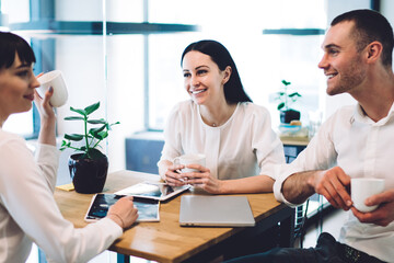 Obraz premium Happy office workers talking in cafe and looking at each other