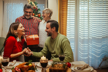 Happy family celebrating christmas exchanging gifts at home