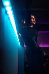 An Elegant Model Dressed in a Chic Black Outfit Poses at a Modern Bar Setting for Photography