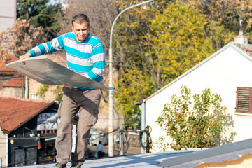 Roofer assembles sheet metal on the roof. A worker  repairing the roof of a home. Roofing